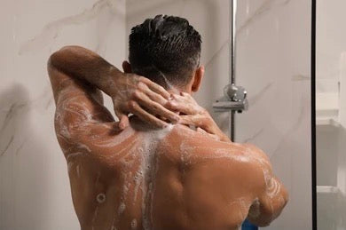 Photo of a mans back using a all-natural men's body wash made with organic ingredients that produce a good lather.