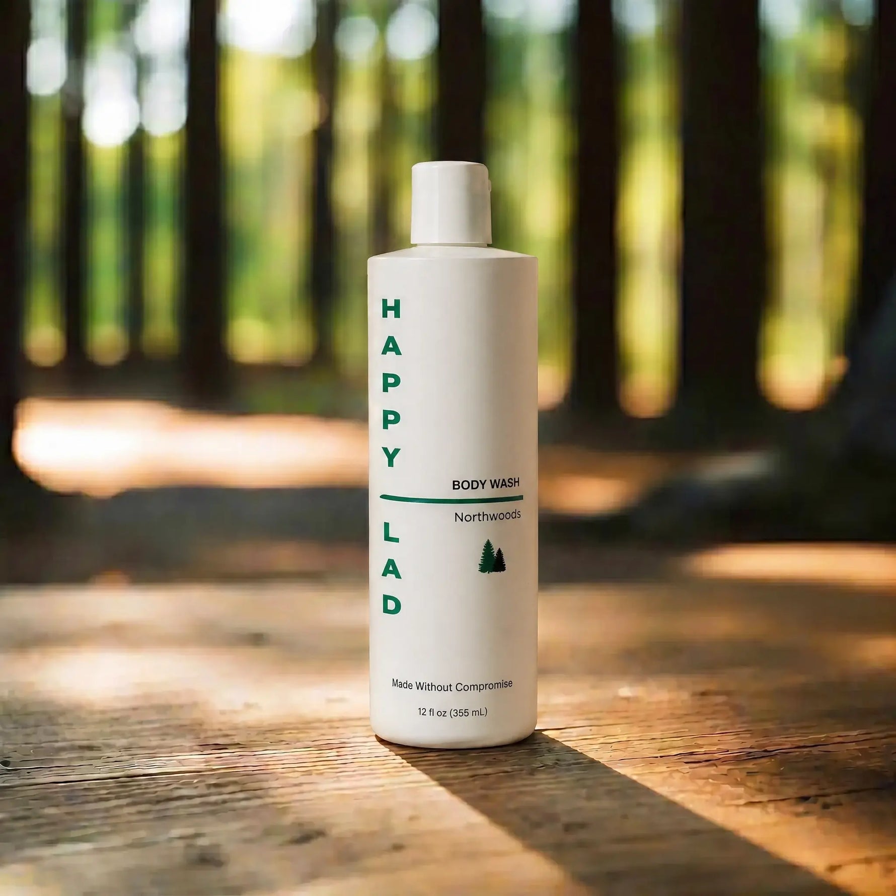 Organic body wash for men that is Northwoods scented with essential oils by Happy Lad on a wooden surface with a forest background.