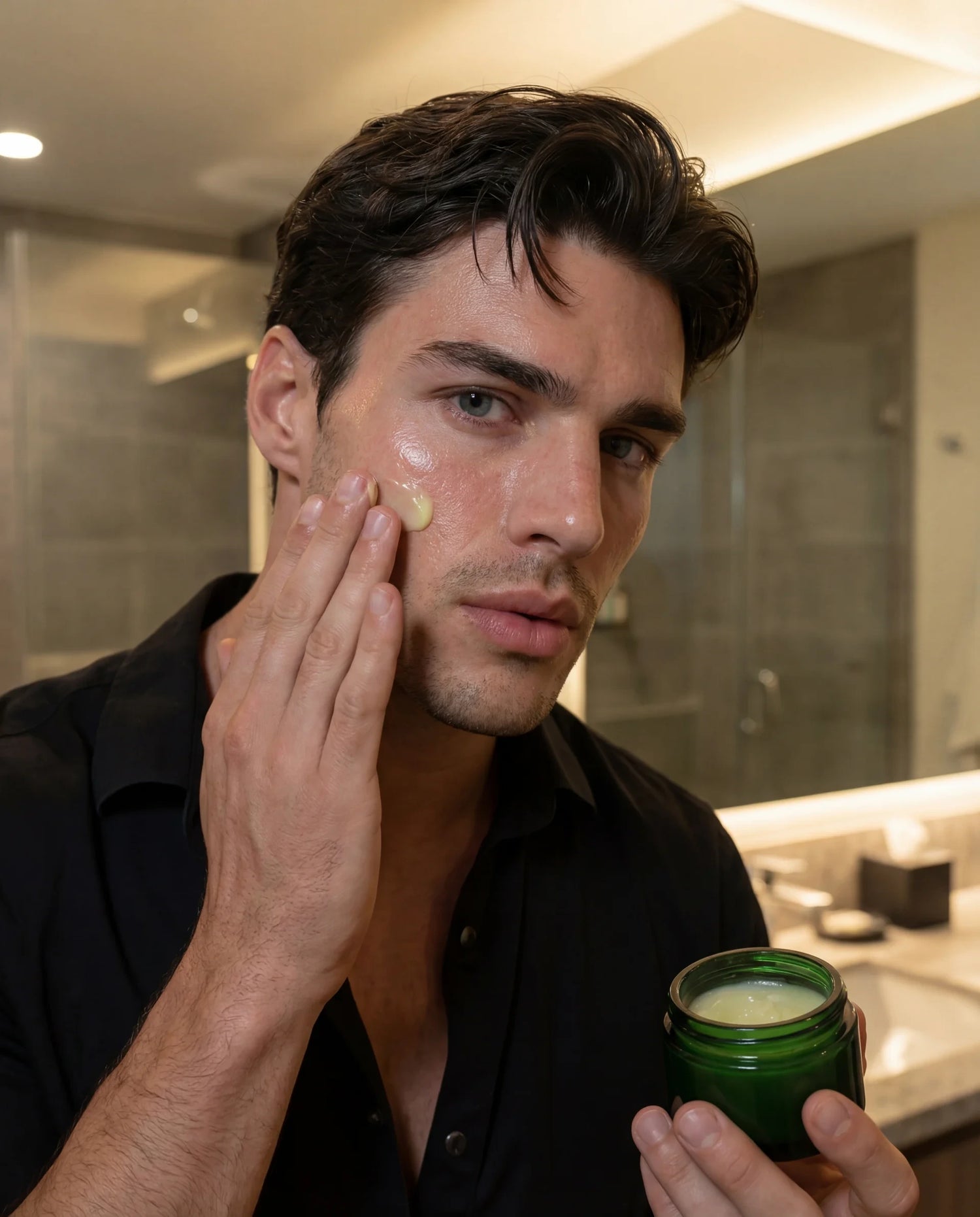 Man applying natural face moisturizer cream to his face in a bathroom setting