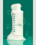Non toxic shampoo for men by Happy Lad with soap bubbles on and around bottle.