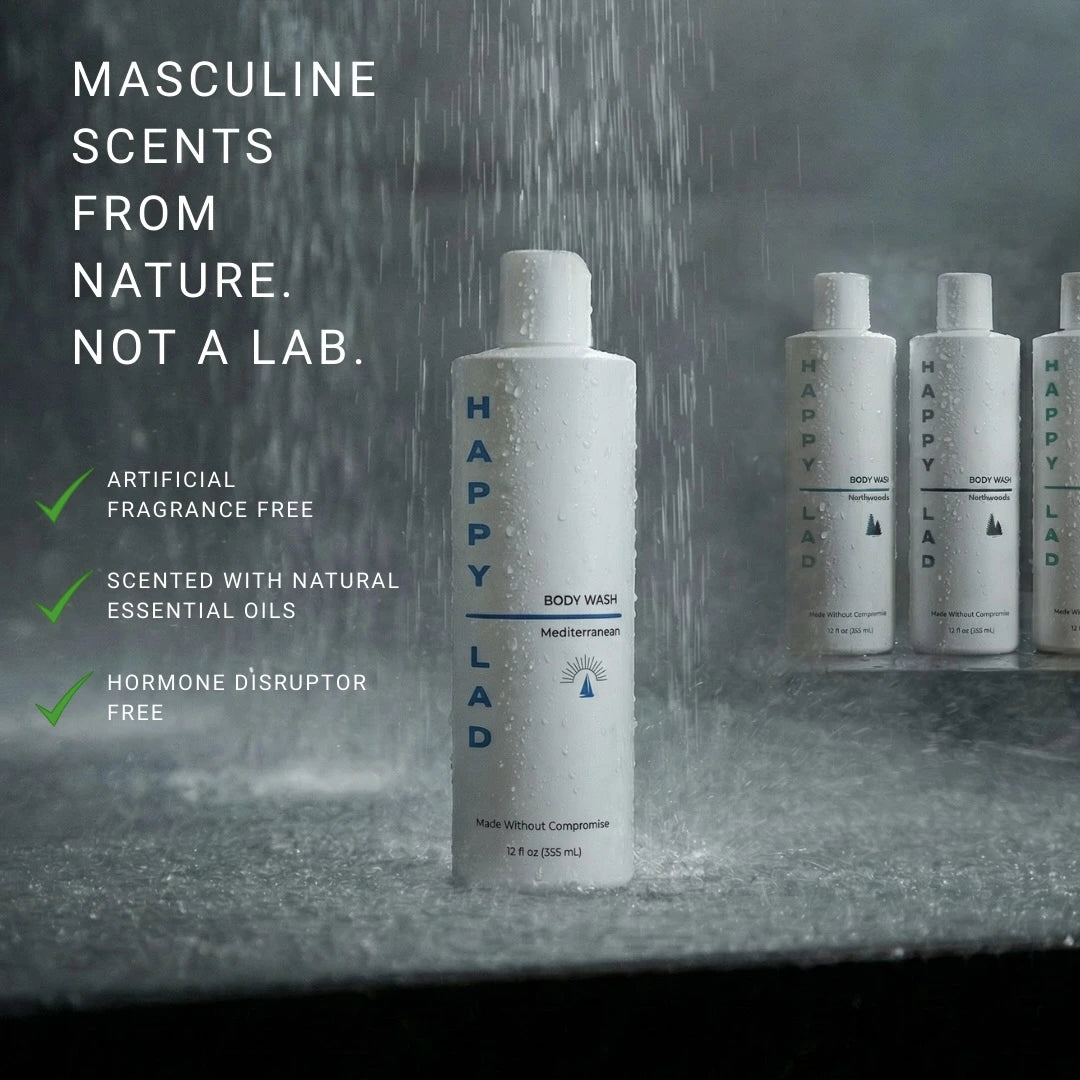 Happy Lad organic body wash bottle with shower head and water droplets on a gray marble background