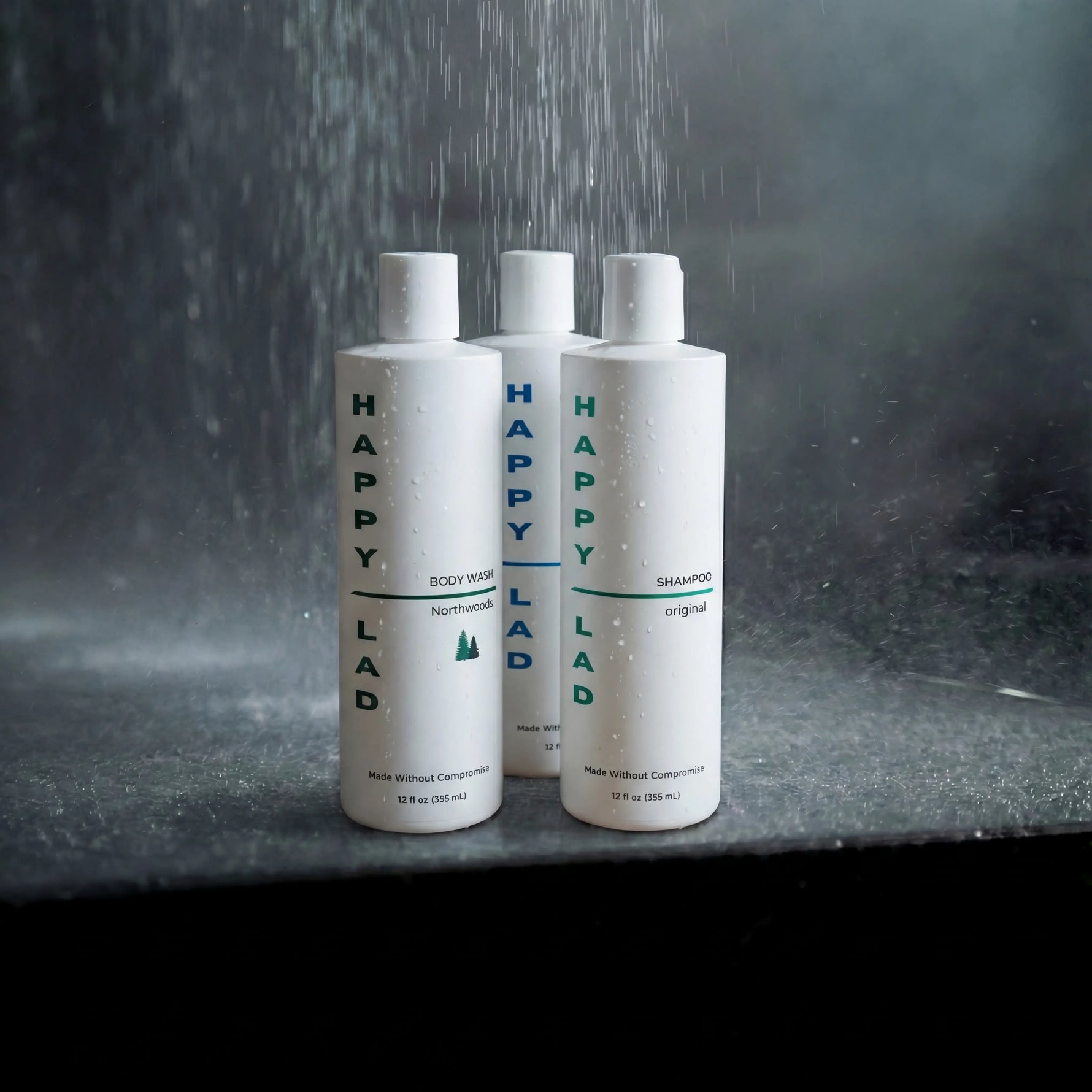 Three bottles of Happy Lad products (organic body wash and natural shampoo) on a dark marble surface with water droplets.